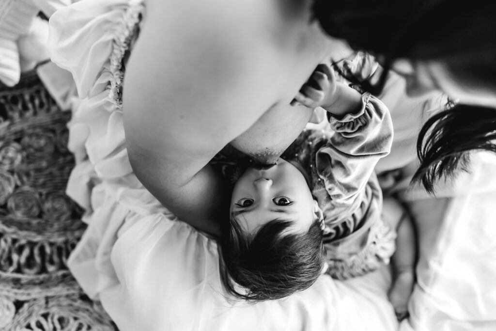Mother breastfeeding her baby outdoors, close-up shot in black and white.