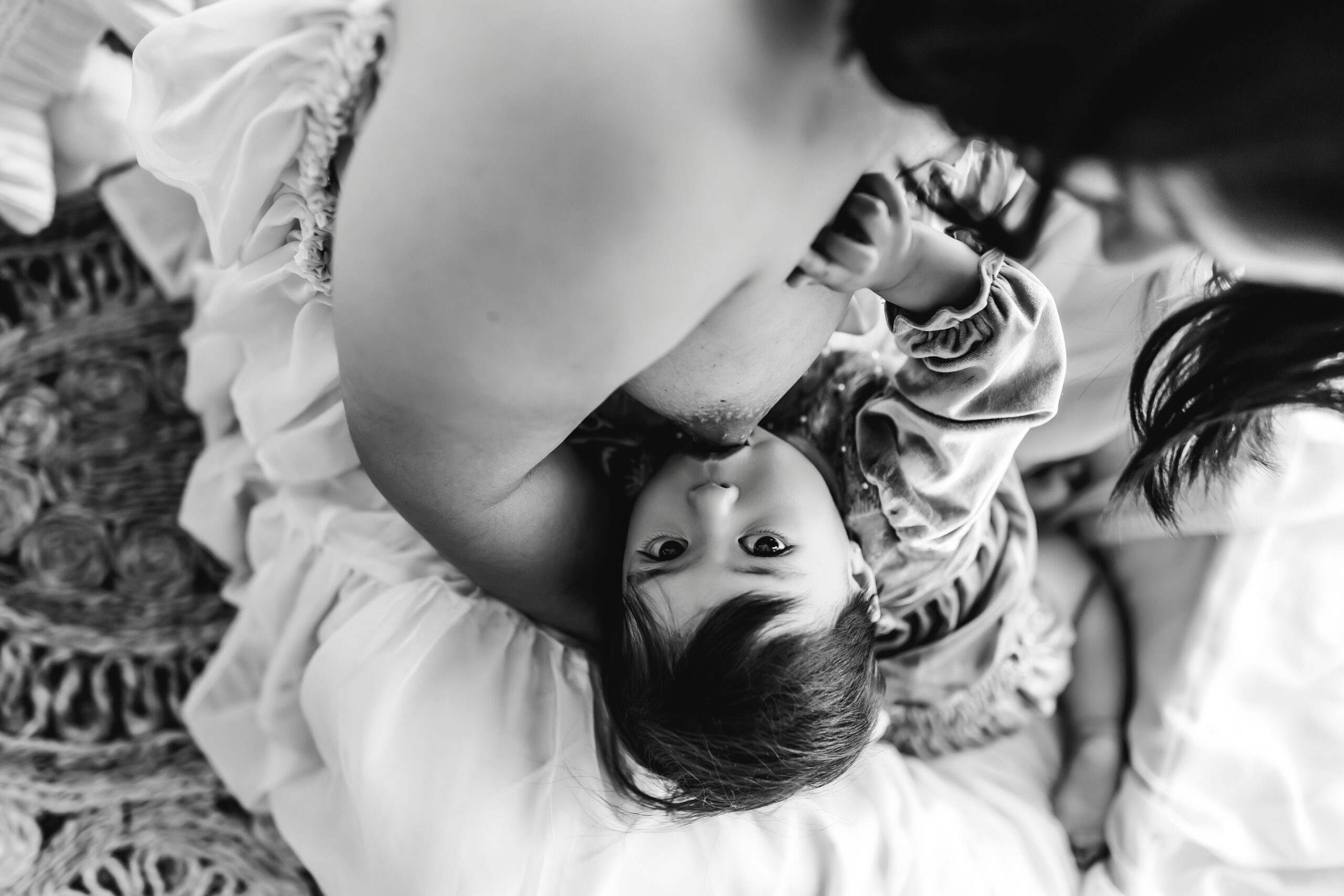 Mother breastfeeding her baby outdoors, close-up shot in black and white.