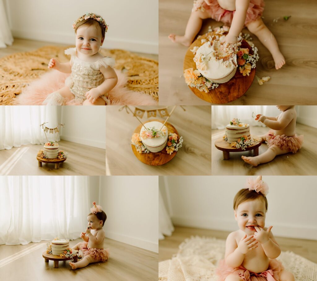 a one year old sits in a studio in a pink tutu eating cake 
