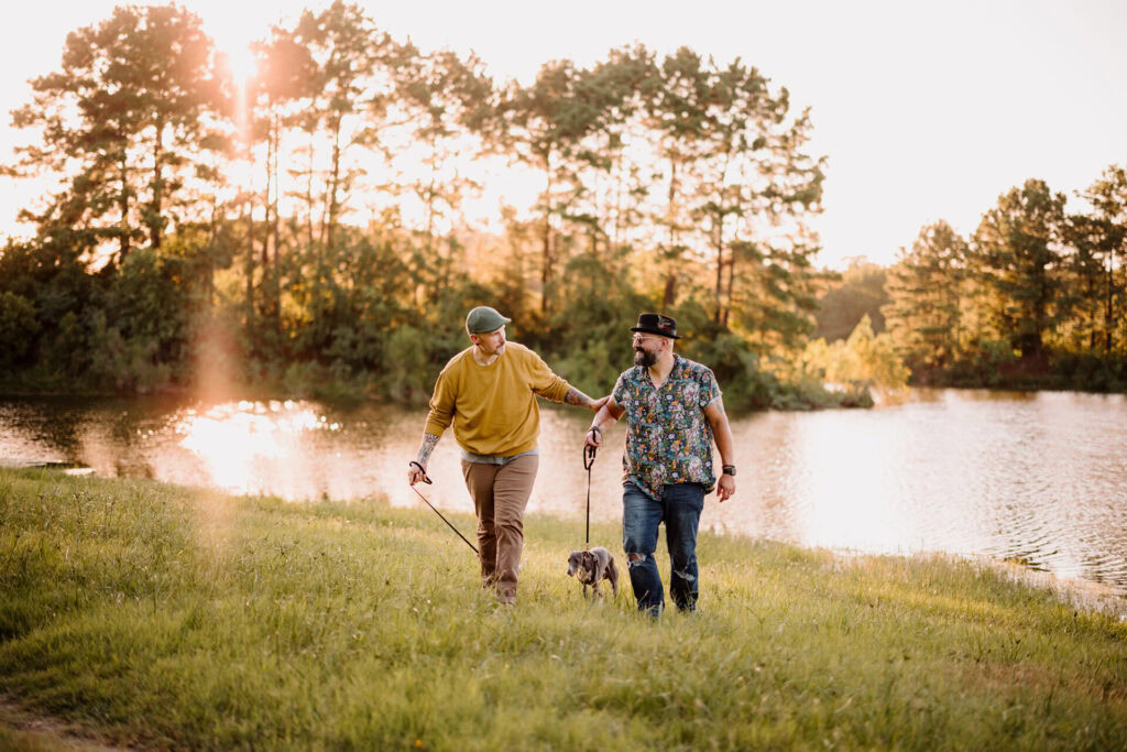 Friends walking with their dog along a scenic lakeside at sunset in The Woodlands, Texas.
