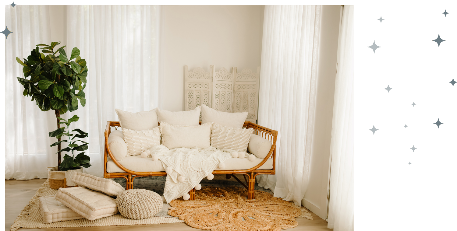 Bright and cozy studio sitting area with white curtains and plush cushions.