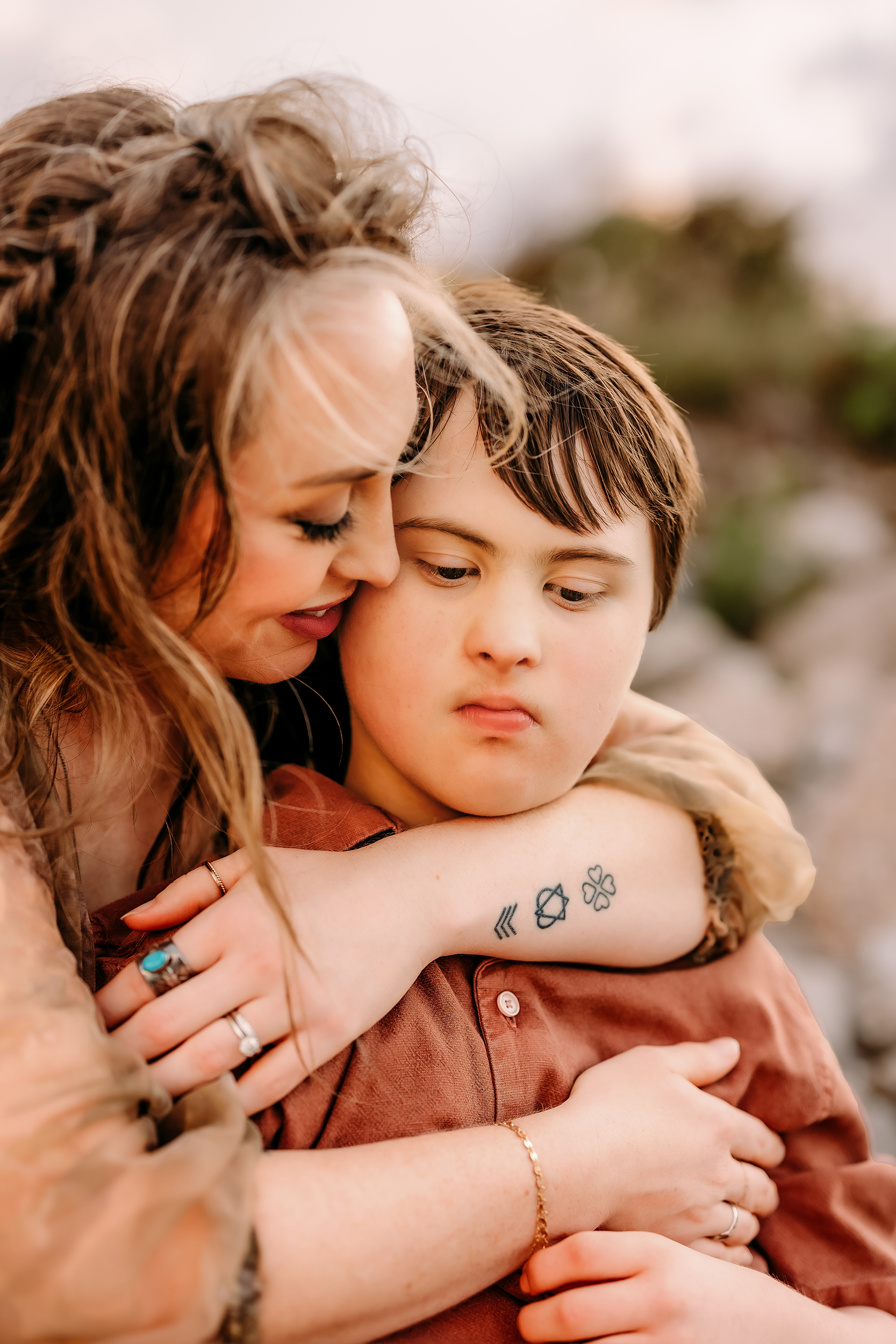 Mother hugging her young son outdoors, capturing a tender moment.