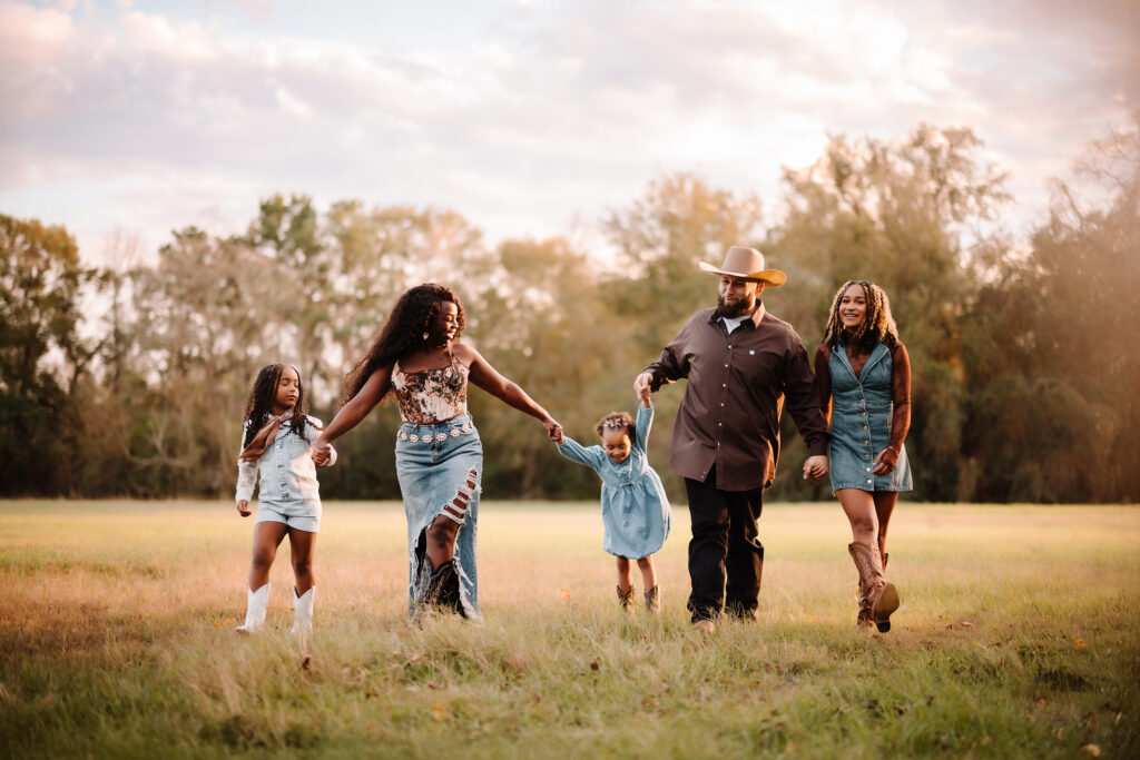 Family outdoor photoshoot in Houston with parents and children holding hands.