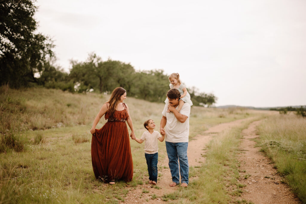 Family walking on a dirt path in The Woodlands during fall mini sessions.